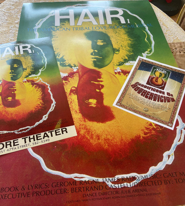 Two 'Hair' theater posters on a table with Certificate of Authenticity.